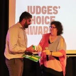 NeoGlycis founder accepts the Judges’ Choice Award from a program facilitator on stage at NextGen Demo Night.