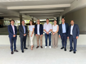 Group of Flo Axiom team members and partners standing together at Griffith University following spinout and investment announcement