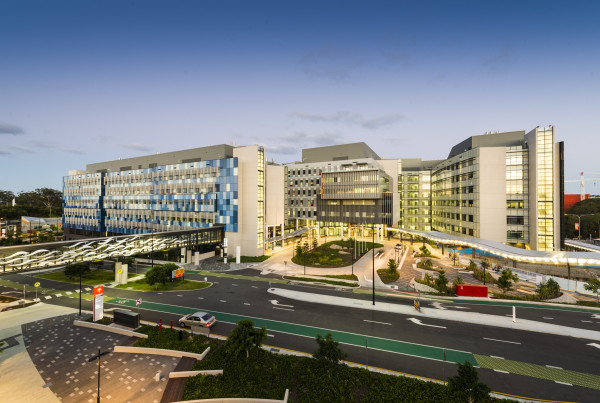 Exterior view of Gold Coast University Hospital following its opening in 2013, showing the modern multi-building hospital facility and landscaped entrance at dusk.
