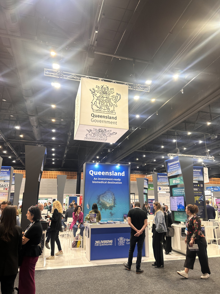 Delegates networking at the Team Queensland exhibition stand during AusBiotech 2026 on the Gold Coast, showcasing Queensland's biomedical industry, biotechnology companies and investment opportunities.