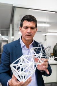 Professor Paulo de Souza holds cube sat prototype models